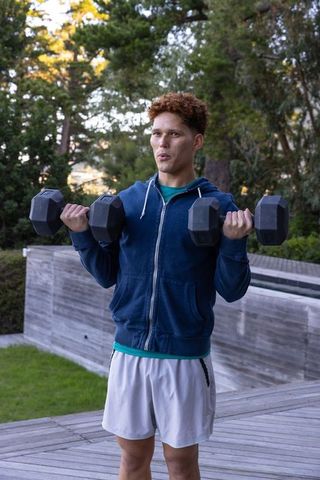 Man in Blue Hoodie Exercising with Dumbbells Outdoor