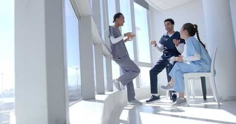 Diverse Healthcare Team Relaxing during Break at Hospital with Bright Views