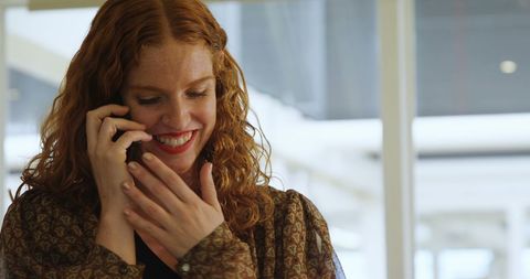 Cheerful Woman Engaging in Positive Phone Call at Work