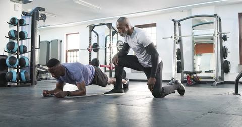 Fitness Trainer Coaching Client in Intense Gym Session