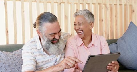 Joyful Senior Couple Enjoying Digital Tablet Interaction