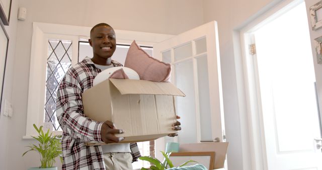 Happy african american man moving into new home. Home ownership, moving house and domestic life, unaltered.