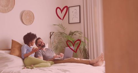 Happy Couple Relaxing Together with Laptop in Cozy Bedroom