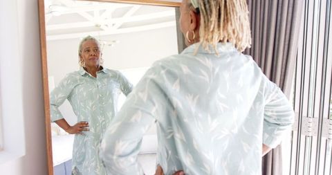 Senior woman contemplative reflection in mirror at home
