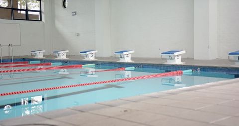 Empty indoor pool with starting blocks and lane dividers