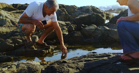 Senior Couple Exploring Rock Pool by the Sea - Download Free Stock Images Pikwizard.com