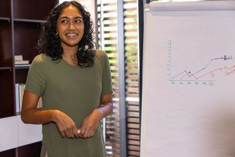 Professional Woman Leading Office Presentation on Data Trends