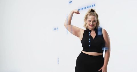 Plus-size woman flexing strong bicep in black activewear with blue data graphics