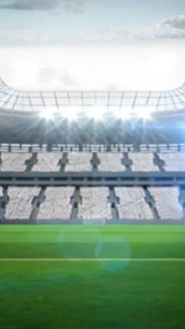 Vertical stadium opening shot with illuminated floodlights, green turf, empty stands for broadcast