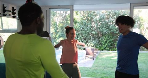 Friends Stretching Together for Home Workout in Modern Living Room
