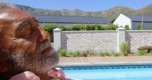 Senior Man Relaxing by Backyard Pool on Sunny Day - Download Free Stock Photos Pikwizard.com
