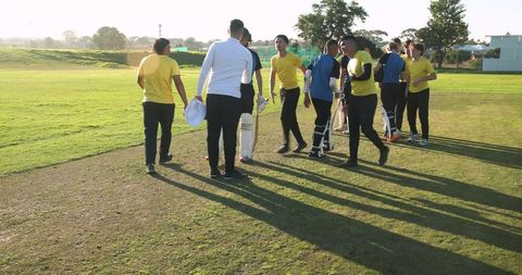 Cricket Team Gathering on Sports Field in Vibrant Jerseys