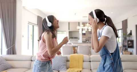 Teenage Girls Having Fun Listening to Music at Home