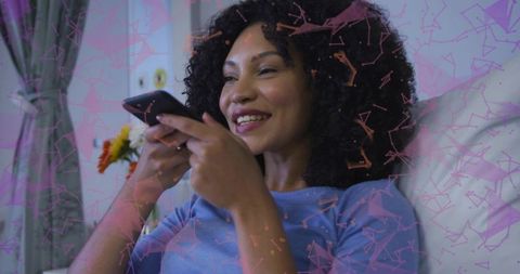 Joyful Woman Relaxing on Bed with Smartphone