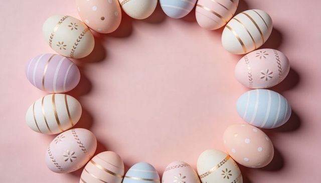 Pastel easter egg wreath with metallic gold accents on pink flat lay, copy space