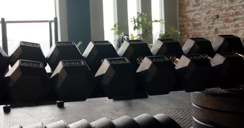 Black hex dumbbells on rack in modern fitness studio