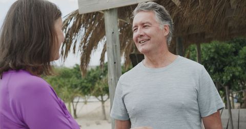 Senior Couple Relaxing at Beach, Enjoying Leisure Time