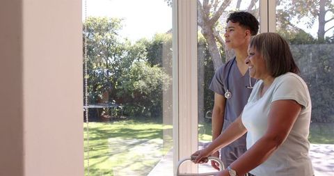 Physiotherapist Helping Elderly Woman With Walker in Rehabilitation Center