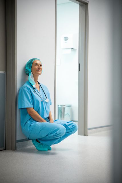 Happy caucasian female doctor wearing stethoscope sitting in hospital corridor. medical and healthcare services at hospital.