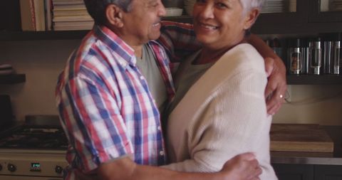 Senior Couple Embracing in Warm Domestic Kitchen Setting