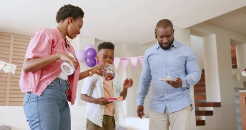 African American Family Celebrating Birthday at Home Pouring Candy into Jar in Living Room