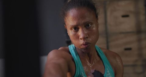 Fierce Biracial Woman Boxing and Training at Gym for Strength