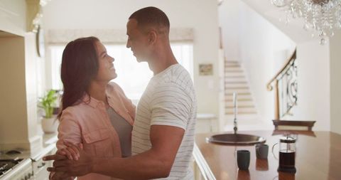 Happy Couple Embracing and Dancing in Modern Home Kitchen