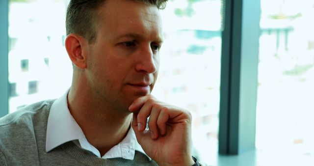 Thoughtful Businessman Sitting by Window in Modern Office - Download Free Stock Images Pikwizard.com