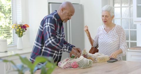 Happy Senior Couple Unpacking Groceries in Kitchen at Home - Download Free Stock Images Pikwizard.com