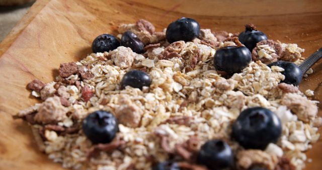 A bowl of oatmeal topped with fresh blueberries and granola, with copy space. Oatmeal is a nutritious breakfast option, often chosen for its health benefits and versatility.