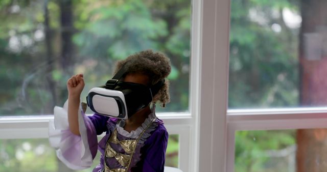 Young girl wearing a princess outfit and using a virtual reality headset. Ideal for technology, childhood imagination, and gaming concepts. Useful in articles, educational blogs, and advertisements for VR technology.