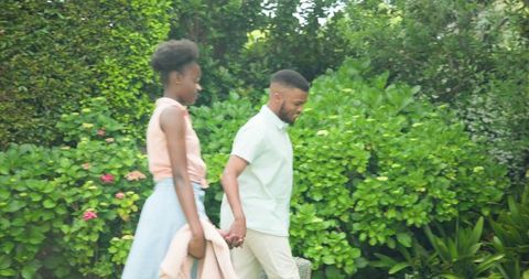 Joyful African American Couple Walking in Nature, Lush Green Backdrop