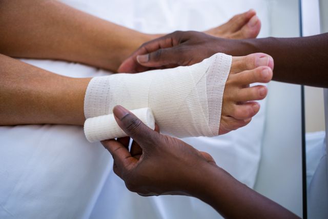 Doctor bandaging patients leg in hospital