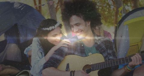 Young Couple Enjoying Music by Campfire at Forest Campsite