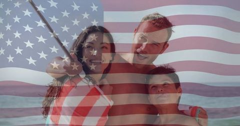 Smiling family posing for beach selfie with american flag overlay celebrating summer fun