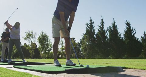 Seniors Enjoy Golf Practice Session on Sunny Golf Course - Download Free Stock Images Pikwizard.com