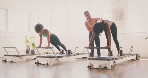 Women Engaged in Pilates Reformer Class in Bright Studio - Download Free Stock Images Pikwizard.com