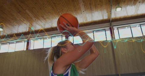 Female Basketball Athlete Shooting in School Gymnasium