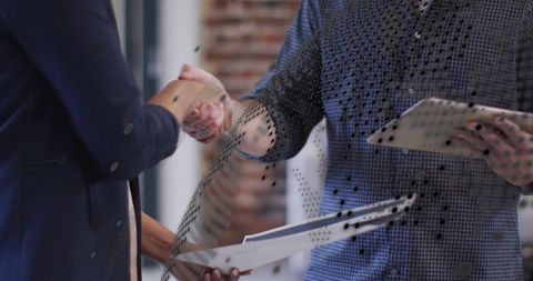 Diverse Business People Shaking Hands Amidst Financial Data Overlay