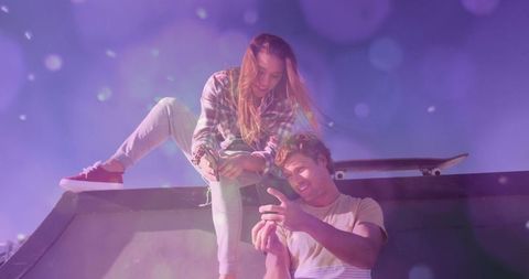 Young friends enjoying skate park with smartphone and skateboard