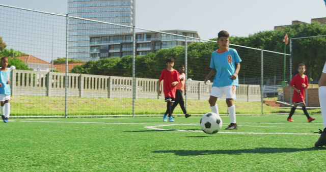 Biracial boys play soccer on a sunny day, with copy space. Outdoor activity captures the energy and teamwork of youth sports.