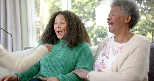 Two happy women on couch laughing and enjoying quality time - Download Free Stock Images Pikwizard.com