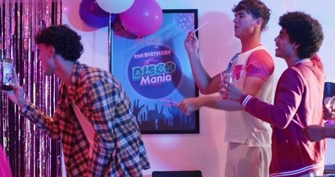 Diverse Friends Celebrating 21st Disco Birthday with Glow Sticks and Balloons