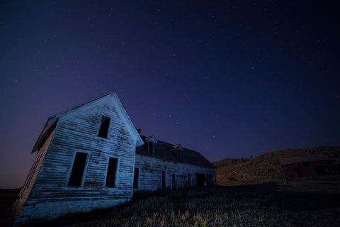 Vintage Rustic Abandoned Farmhouse Under Night Sky