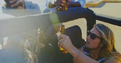 Friends Enjoying Outdoor Celebration with Amber Bottles