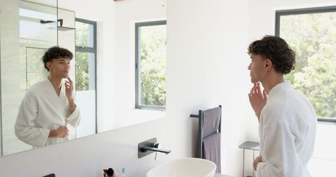 Young man grooming in modern bathroom interior
