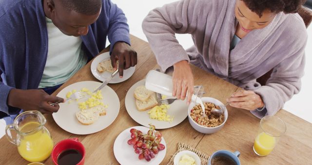 Image of happy african american couple eating breakfast together. Love, relationship and spending quality time together concept.