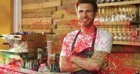 Smiling barista standing with arms crossed behind rustic cafe counter with espresso machine