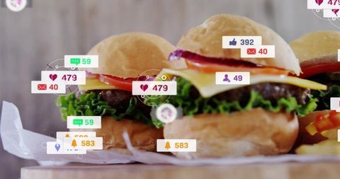 Gourmet mini burger sliders with social media notifications on wooden board