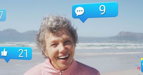 Joyful Senior Woman with Social Media Notifications on Beach - Download Free Stock Images Pikwizard.com